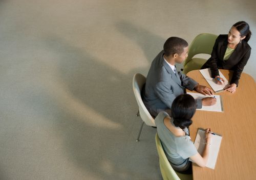 Three people sitting at a table having a work meeting