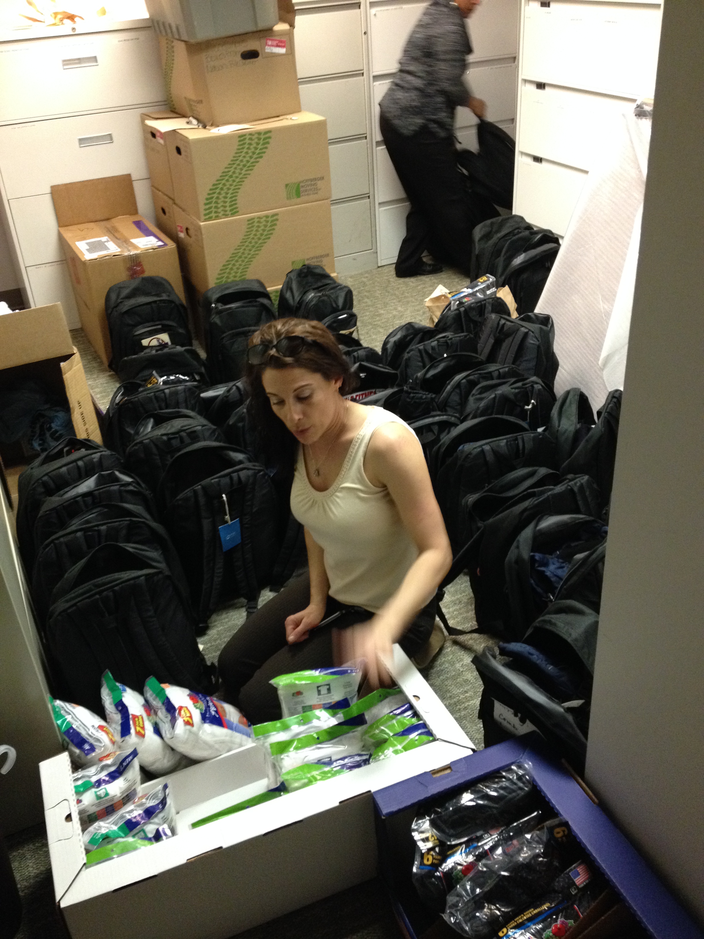 Shelly Kizina stuffs and organizes backpacks.