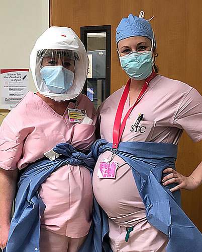 Photo of two pregnant CRNAs standing together smiling