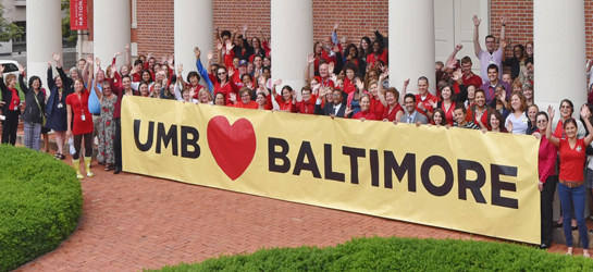 Staff holding a sign that says we love baltimore.