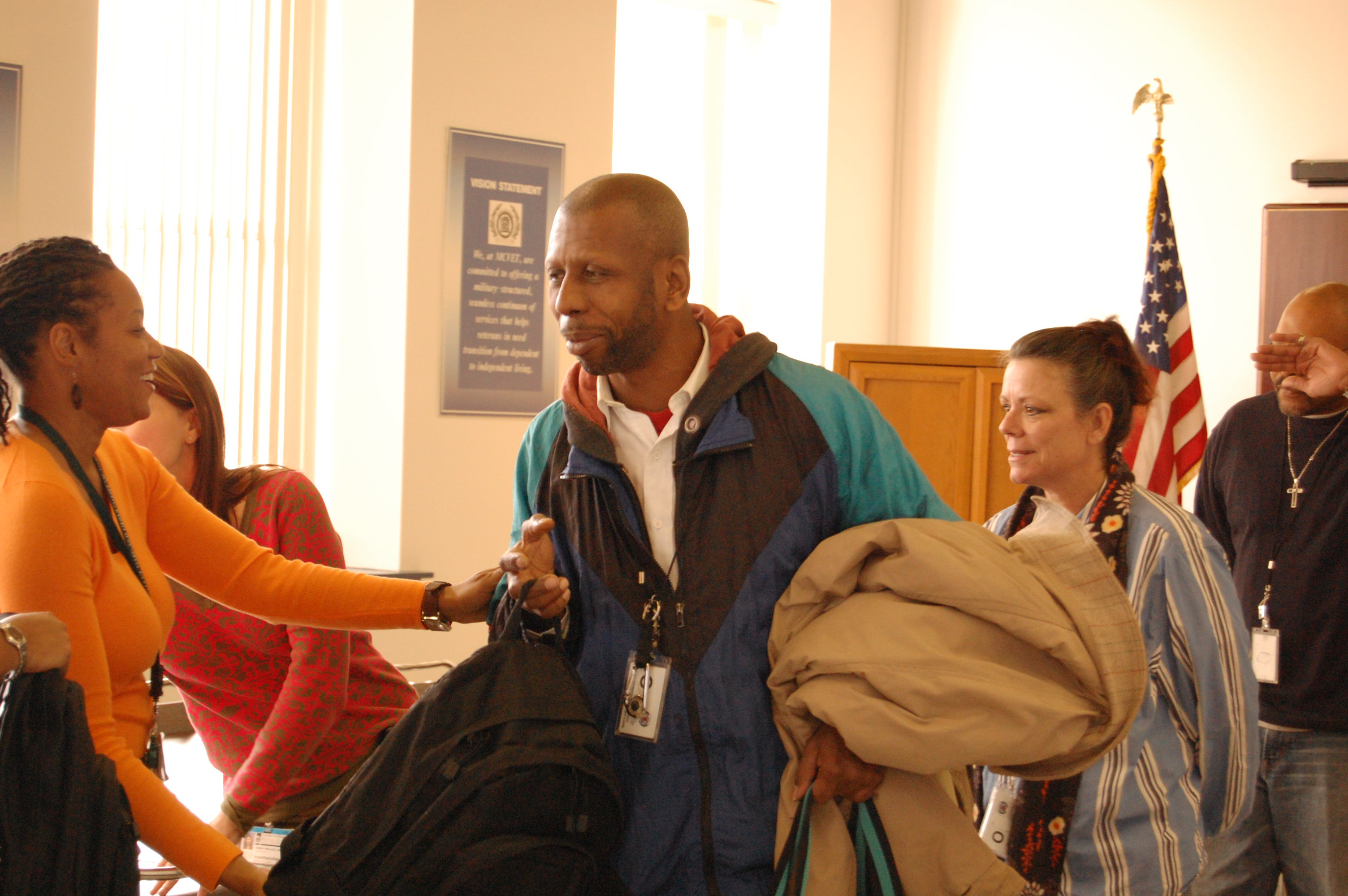Anesthesiology Department staff hand each veteran their backpacks, and shake each of their hands.