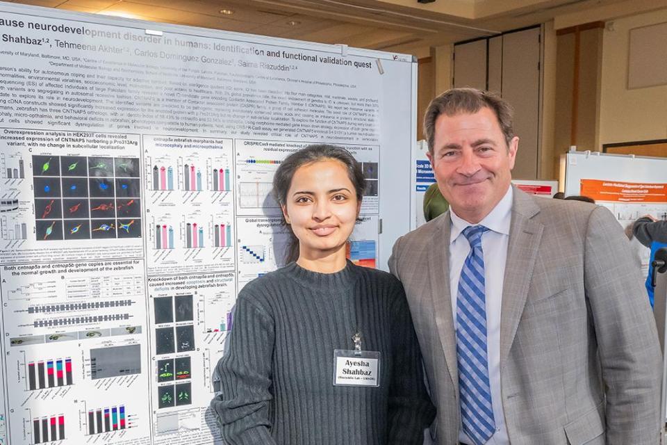 Man with female student in front of scientific poster
