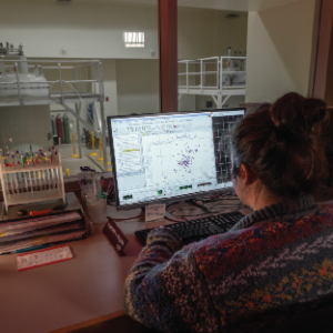 woman sitting in front of NMR workstation