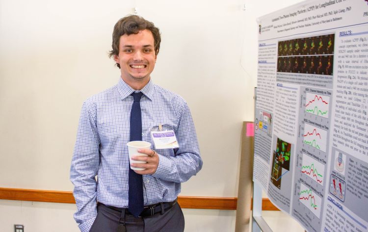 Photo of a young man presenting a poster