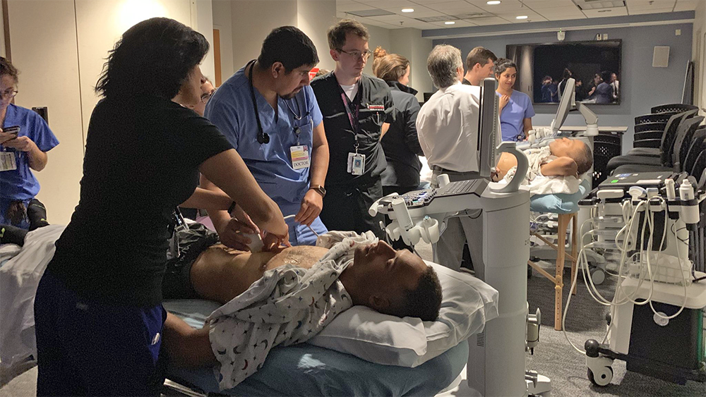 Faculty practicing point-of-care ultrasound in dark room