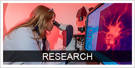 Text: Research Background: Female researcher looking into a microscope