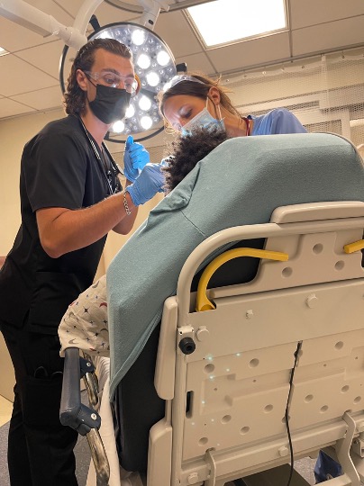 EM residents performing scope procedure