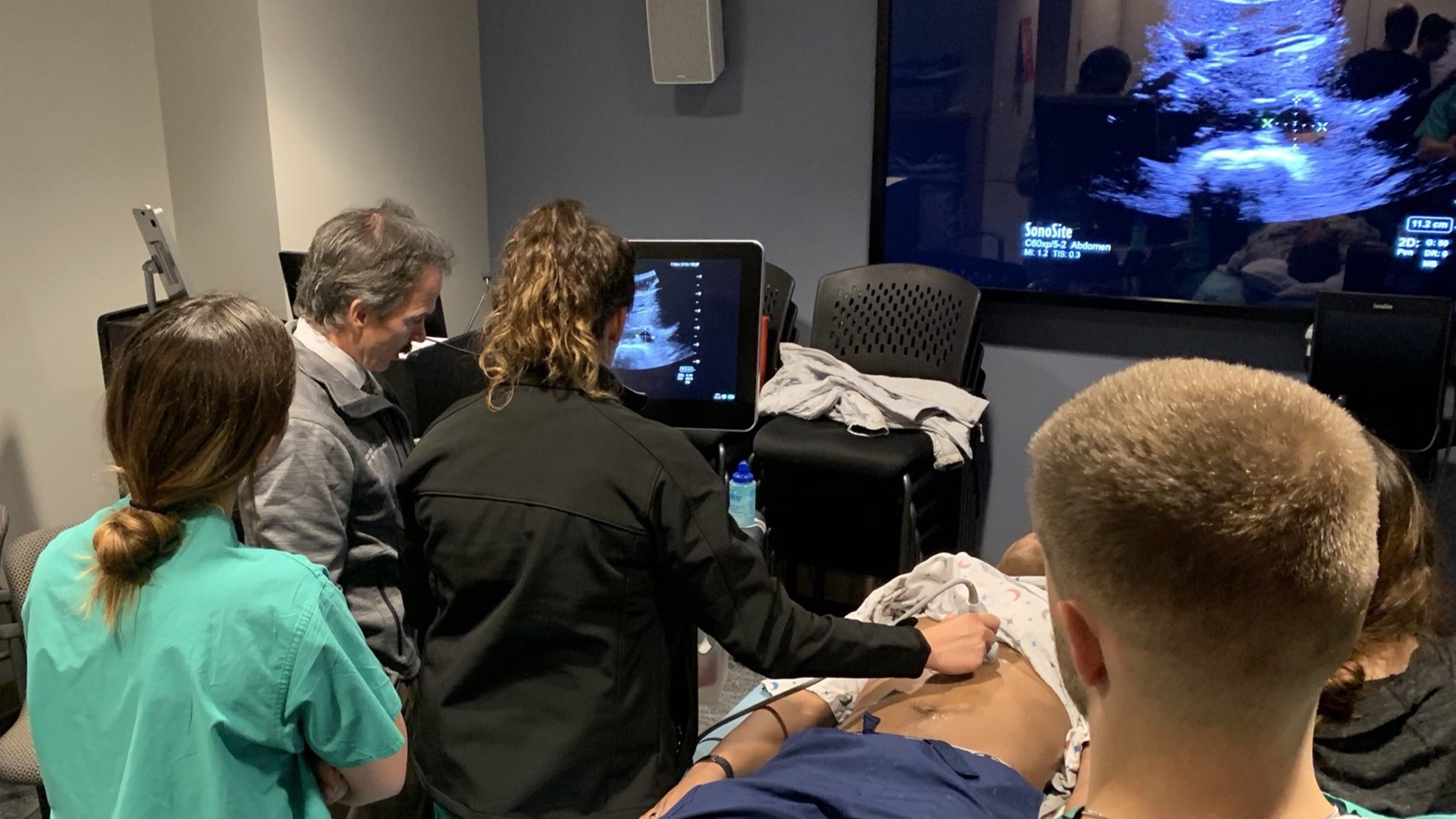 Picture of physician learners practicing ultrasound on a live model