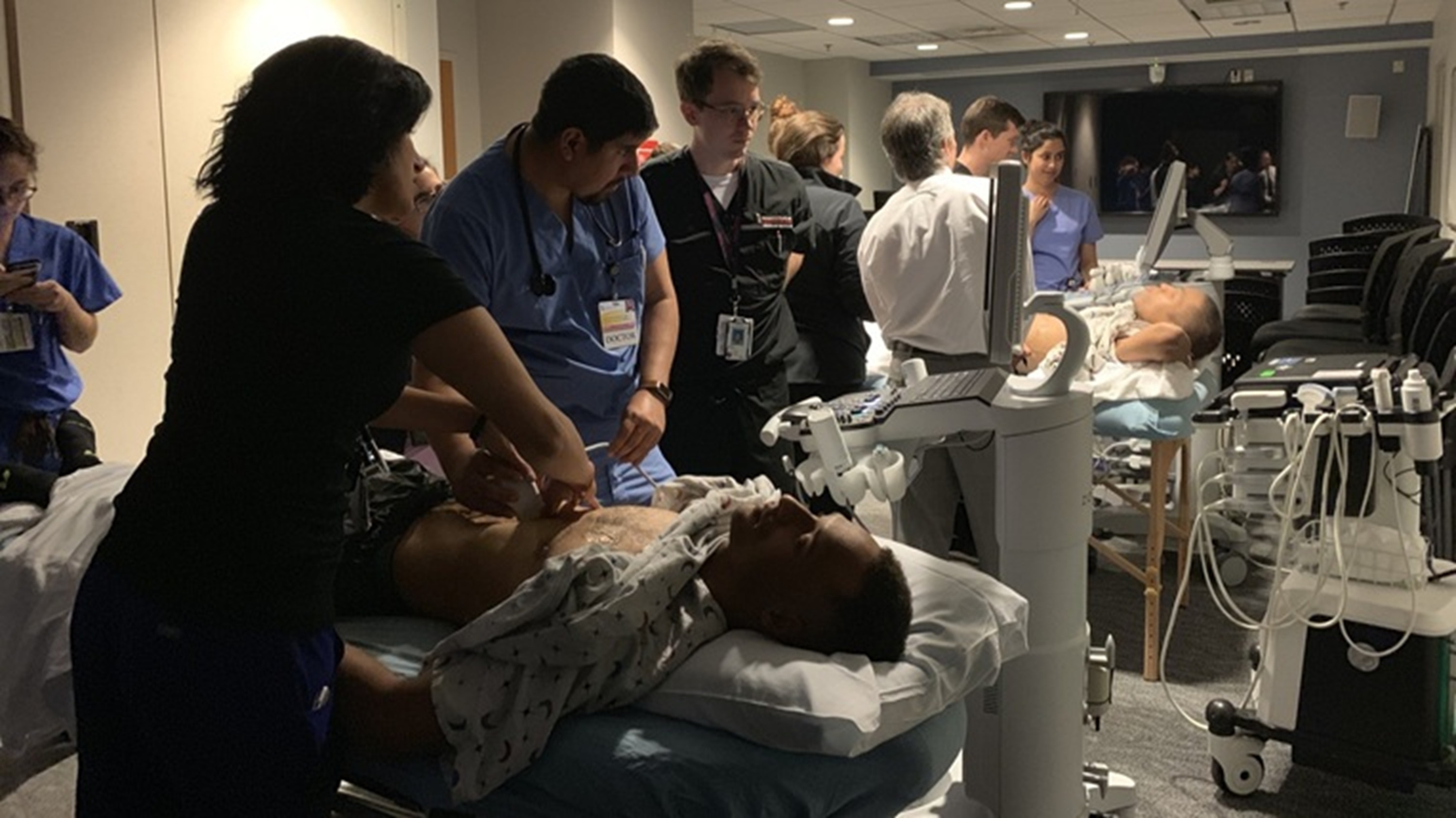 Picture of physician learners practicing ultrasound on a live model