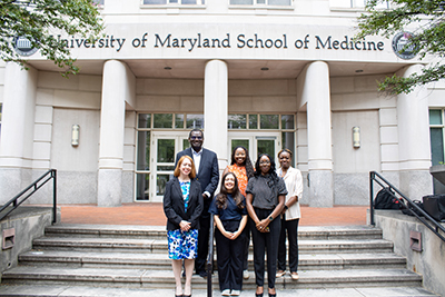 Faculty and staff in the Cancer Epidemiology division pose outside the University of Maryland School of Medicine building