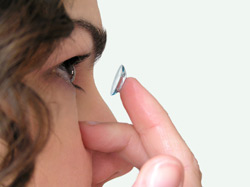 Woman putting contact lens in eye