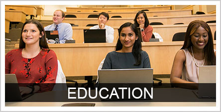 Education text with students in a classroom with laptops in the background
