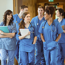 Group of medical students wearing scrubs walking