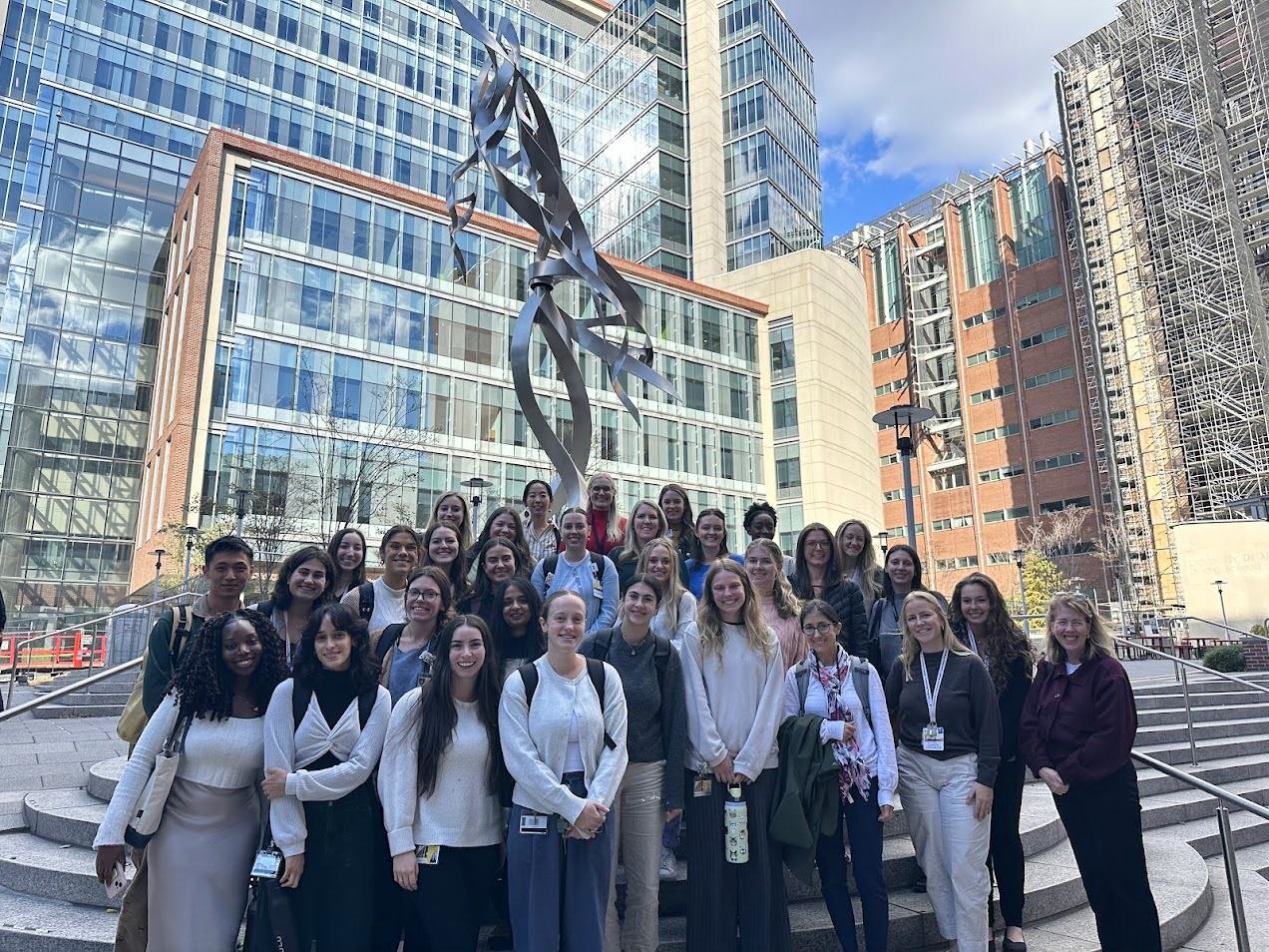 Picture of genetic counseling students and faculty in front of a DNA statue