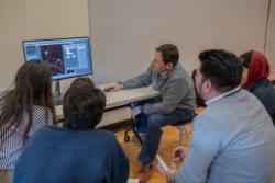 A Nikon representative presents their software to a small group of attendees