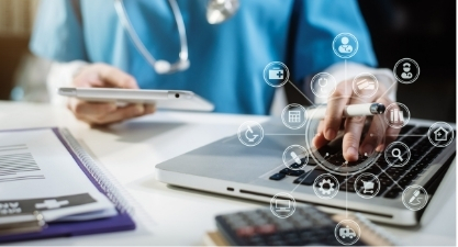 Healthcare provider using a laptop and tablet