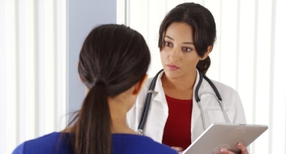 Healthcare provider with a clipboard talking to a patient