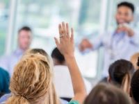 medical student raising hand and presenter pointing