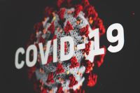 Photo of Covid molecule with COVID-19 in white text across it