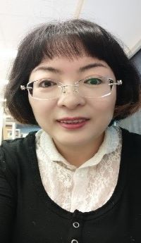 Photo of Hongxia Chen wearing a black cardigan with white lace blouse