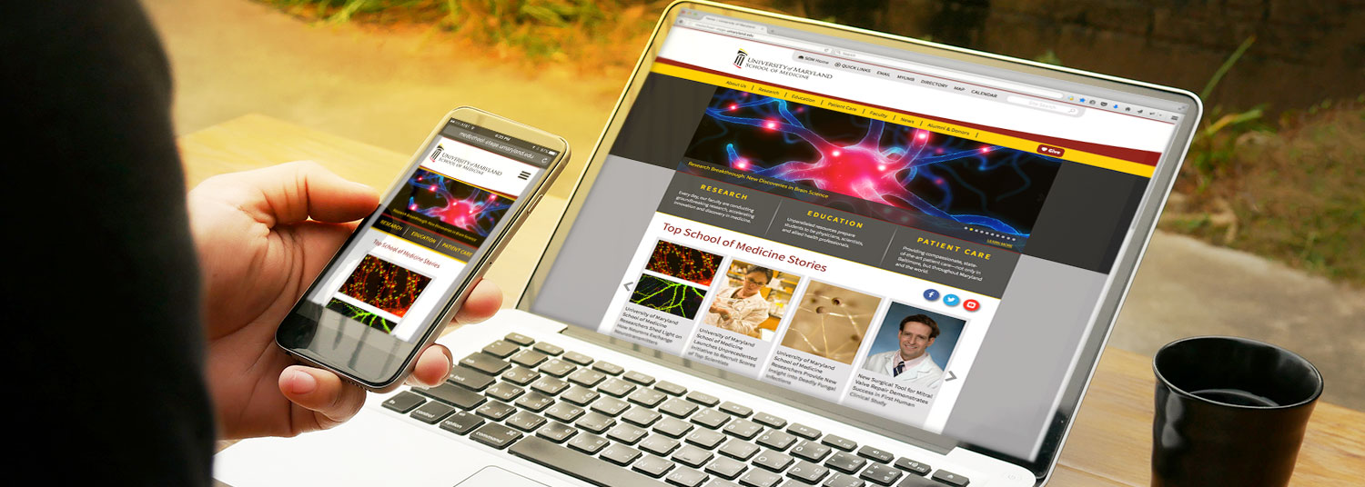 Laptop with screen showing UMSOM website