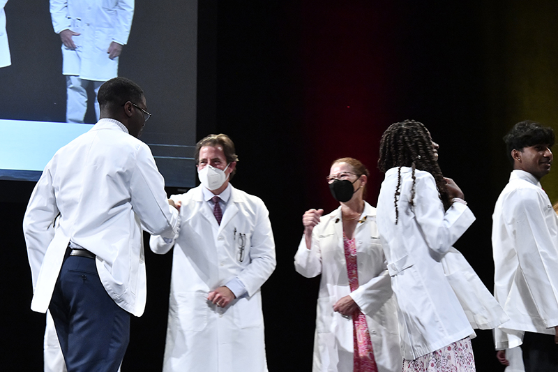 Students receiving white coats
