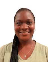Student headshot. Woman standing in front of a white background wearing a beige shirt.