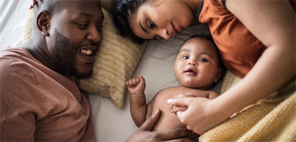 Parents cuddling with a baby
