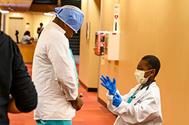 Doctor speaking with a Mini-Med School student dressed as a doctor