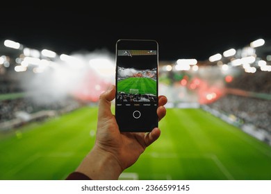 Hand holding a cell phone with sports event