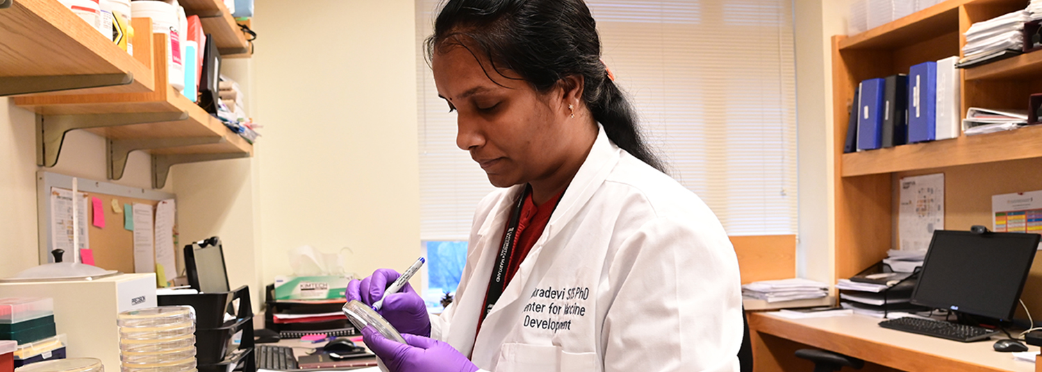 Person labeling a petri plate.